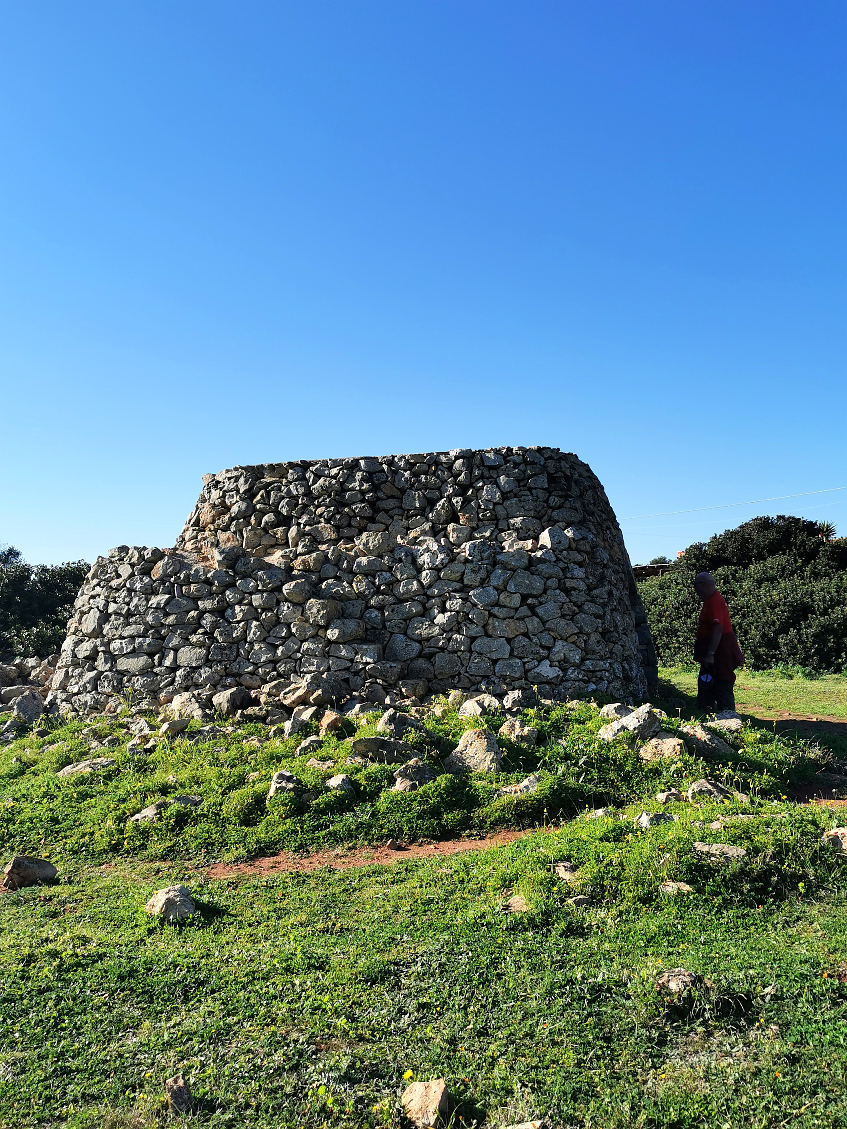 Vor der Hitze flüchteten sich die Landarbeiter in selbst errichtete Trulli-Schutzhütten, die auf den Feldern und Weiden stehen. Aus Kalksteinen aufgeschichtet, sind sie mal rund mal eckig, meist haben sie die Form eines Kegelstumpfes mit Dachterrasse, zu der eine Aussentreppe hinaufführt.